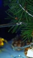 Robotic arm adjusting Christmas decoration on the pine-tree. Little claw dealing with delicate work. Close up. Vertical video