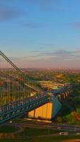 Bridge with busy traffic leading to Bronx. Green part of the city in the rays of setting sun. Top view. Vertical video