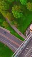 Cars and lorries passing by the lively motorways. Top view on the road junctions in busy metropolis. Vertical video