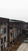 Aerial view of an old factory ruin and broken windows. Old industrial building for demolition. Vertical video