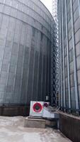Interior of the steel cisterns at modern elevator factory. Working ventilators at the granary tank. Going round the wide cistern of grain storage complex. Vertical video