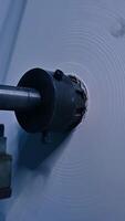 Enormous rotating roll of white ribbon. The reel of cloth used for the manufacturing of diapers at the factory. Close up. Vertical video