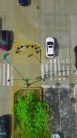 Traffic of a busy city at daytime. Automobiles moving quickly by the broad roads. View from top. Vertical video