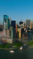 New modern creative buildings of Manhattan Island. Flying along the waterfront built up with numerous buildings covered with slight fog. Vertical video