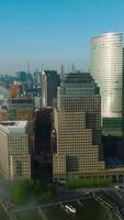 Sun rays reflecting in the windows of beautiful skyscrapers in Lower Manhattan Financial District. Tremendous New York cityscape neighboring with Hudson river covered with fog. Vertical video