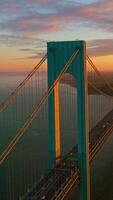 Wonderful construction of Whitestone bridge in New York. Huge massive bridge in the lights of setting sun. Vertical video