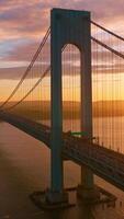 Calm waters of East River at setting sun. Beautiful construction of Whitestone bridge with quick traffic. Vertical video