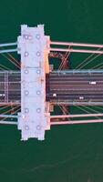 Speed motorways on the Whitestone bridge in New York. Flying high over the bridge construction at the backdrop of turquoise water of river. Vertical video