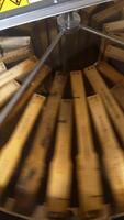 Frames with honeycombs rotating in the centrifuge device for removing honey. Harvest season at bee farm. Close up. Vertical video