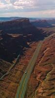 Spectacular view of huge rocks in the national park of Utah, USA. Roads passing through the canyons on sunny hot day. Aerial view. Vertical video