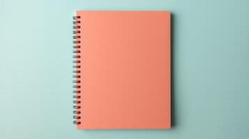 A pink spiral notebook sits on a blue background photo