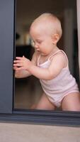 A curious toddler joyfully explores the captivating space around a bright window area video