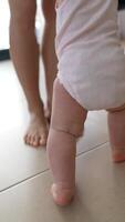 A toddler joyfully taking their very first steps while having a caring parent nearby video