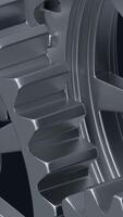 A close-up perspective showcases a series of rotating interlocking metal gears, highlighting the precise engineering and the complexity of mechanical design in machinery. vertical footage video