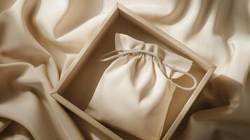 Simple drawstring bag mockup rests inside minimalist beige box. Calm simplicity. Smooth fabric giftbox template advertising image. Sustainable packaging mock up product photorealistic photo