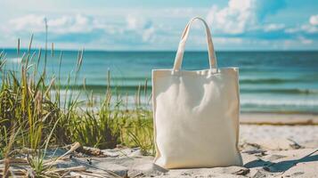 Canvas tote bag mockup on seaside dunes surrounded by tall grasses. Tranquil totebag template advertising image. Gentle waves and bright blue water nature mock up product photorealistic photo