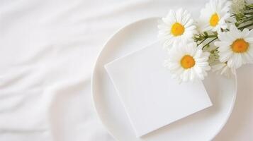 Blank card mockup with daisies on white plate. Fresh chamomiles elegant composition. Wedding invitation template advertising image. Greeting card mock up product photorealistic photo