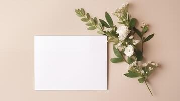 Blank white card mockup on beige surface with delicate flowers green leaves. Elegantly arranged paper template advertising image. Soft color palette mock up product photorealistic photo