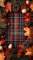 Autumn Leaves and Pine Cones on Plaid Fabric Background photo