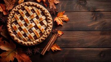Homemade Apple Pie with Cinnamon Sticks and Autumn Leaves on Rustic Wooden Background photo