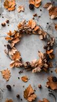 Autumn Wreath with Leaves Pine Cones and Acorns on Grey Background photo