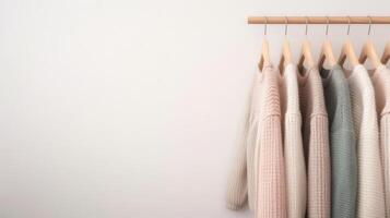 A rack of sweaters hanging on a wall photo