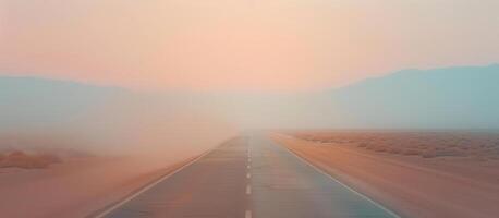 An empty road in the desert with a foggy sky photo