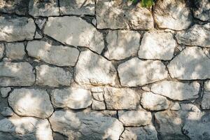 Stone Wall with Sunlit Patches and Shadows photo
