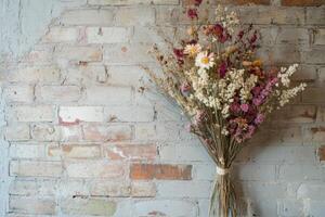 Dried Flower Bouquet Against Weathered Brick Wall photo