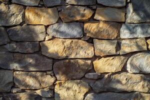 Close-Up of Rough Stone Wall with Sunlit Texture photo