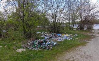 Plastic, polyethylene and glass trash in the wild, environmental pollution photo