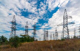 High-voltage lines on steel structures with wires against the background of the sky with clouds photo