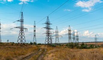 High-voltage lines on steel structures with wires against the background of the sky with clouds photo