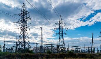 High-voltage lines on steel structures with wires against the background of the sky with clouds photo