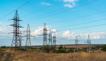 High-voltage lines on steel structures with wires against the background of the sky with clouds photo