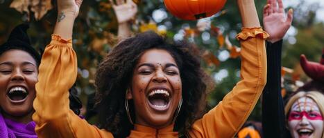 A group of women in halloween costumes holding up pumpkins photo