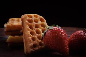 Viennese waffles in the shape of a heart lie on a clay plate. Viennese waffles with strawberries. photo