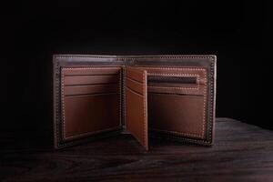 An open leather wallet on a dark background. photo
