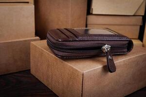A beautiful leather wallet lies on paper boxes. photo