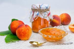 Peach jam in the jar on the table photo