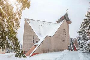 snowy church after a blizzard, avalanche danger, snow falling from the roof photo