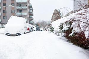 Poland, Krakow, 12.03.2023, snowfall, snowy street with cars after a blizzard photo