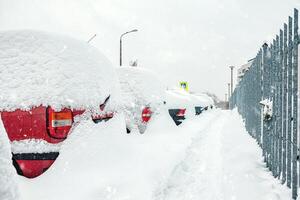 Poland, Krakow, 12.03.2023, snowfall, snowy street with cars after a blizzard photo