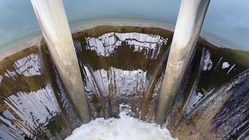 water flowing from a reservoir down into a spillway, footage shows powerful, steady stream of water as it is released, emphasizing both nature and engineering in water management, conservation, dam video
