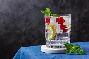 Raspberry cocktail with ice in a glass on a marble photo