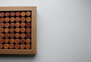 Cardboard tray with wine corks on white surface on a side of photography concept for postcard or wallpaper photo