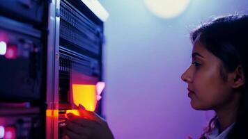 Woman IT specialist fixing server rack glowing LED engineer system administrator girl software hardware security cloud computing AI expert specialist technology data center network video