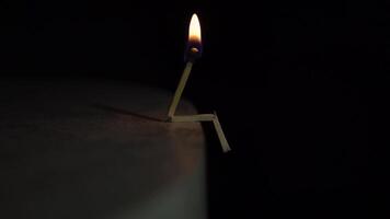 The concept of a sad person. burning match on a light surface in the dark. video