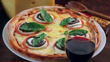 A pizza with cheese, tomatoes and basil on a plate video