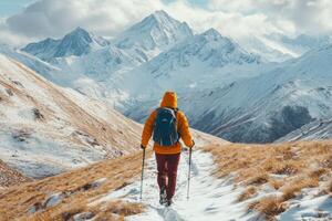 Hiker walking in snowy mountains on sunny winter day photo